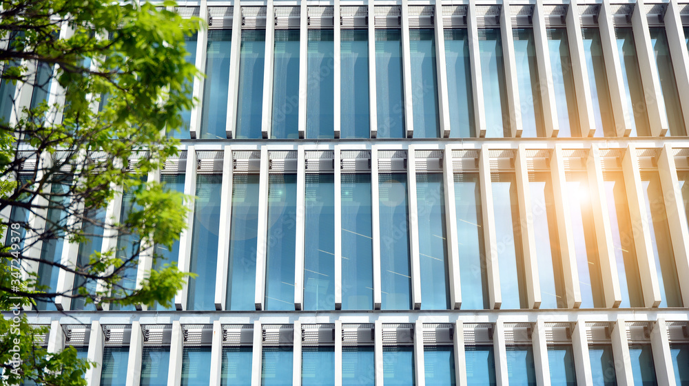 Modern architecture with sun ray. Glass facade on a bright sunny day with sunbeams on the blue sky.