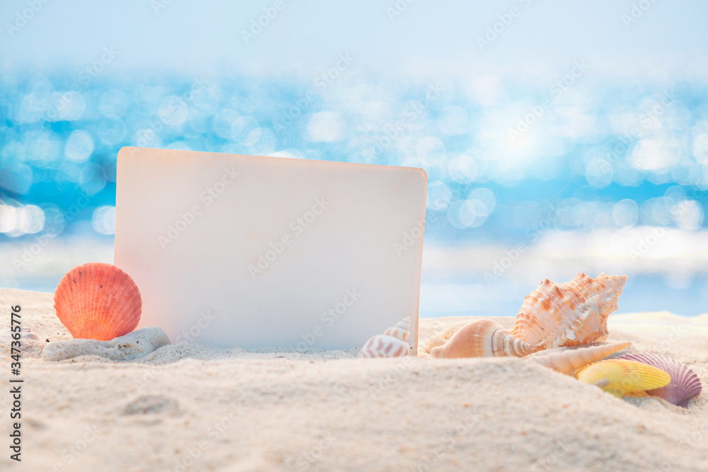 Sandy beach with empty paper card for message design. blur sea on background. Tranquil beach scene f