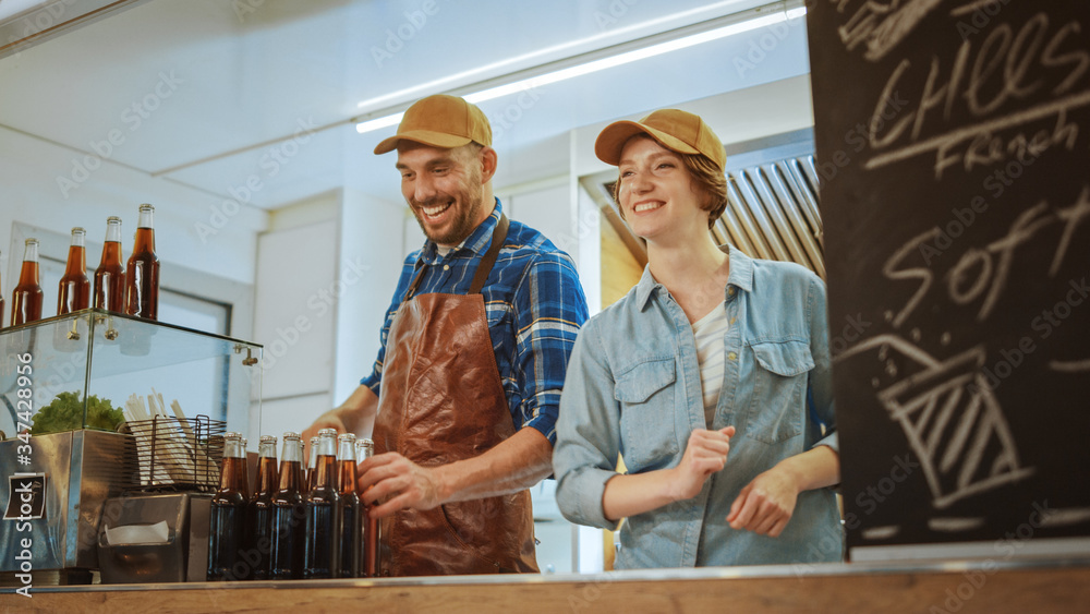 Successful Food Truck Male and Female Employees in Brown Caps. They are Cheerful and Smiling. Commer