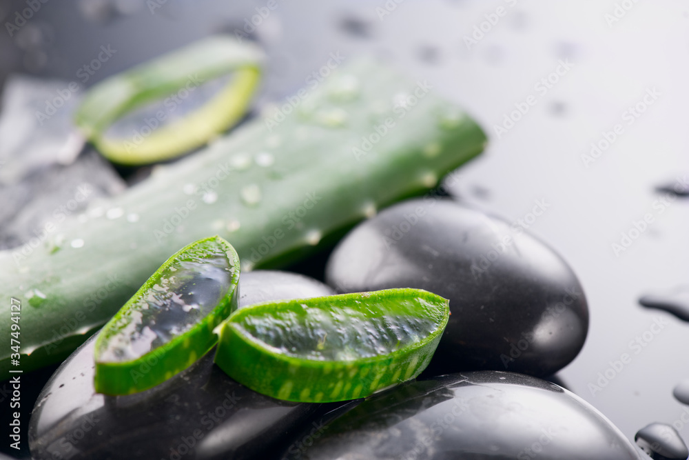 Aloe Vera slices and spa stones closeup. Aloevera plant leaf gel, natural organic renewal cosmetics,