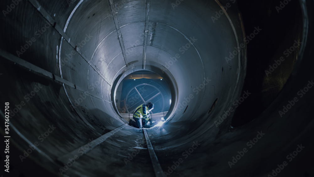 Professional Heavy Industry Worker Wearing Helmet Welding Inside Oil and Gas Pipe. Construction of t