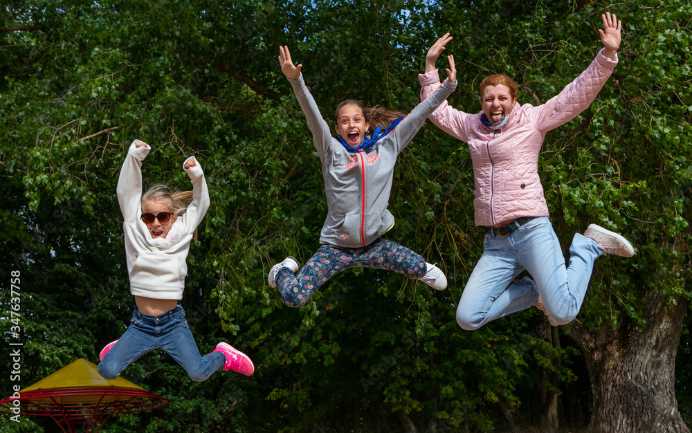 Fun people jumping and laughing.  Happy smiling family consist of  mother and two daughters out of h