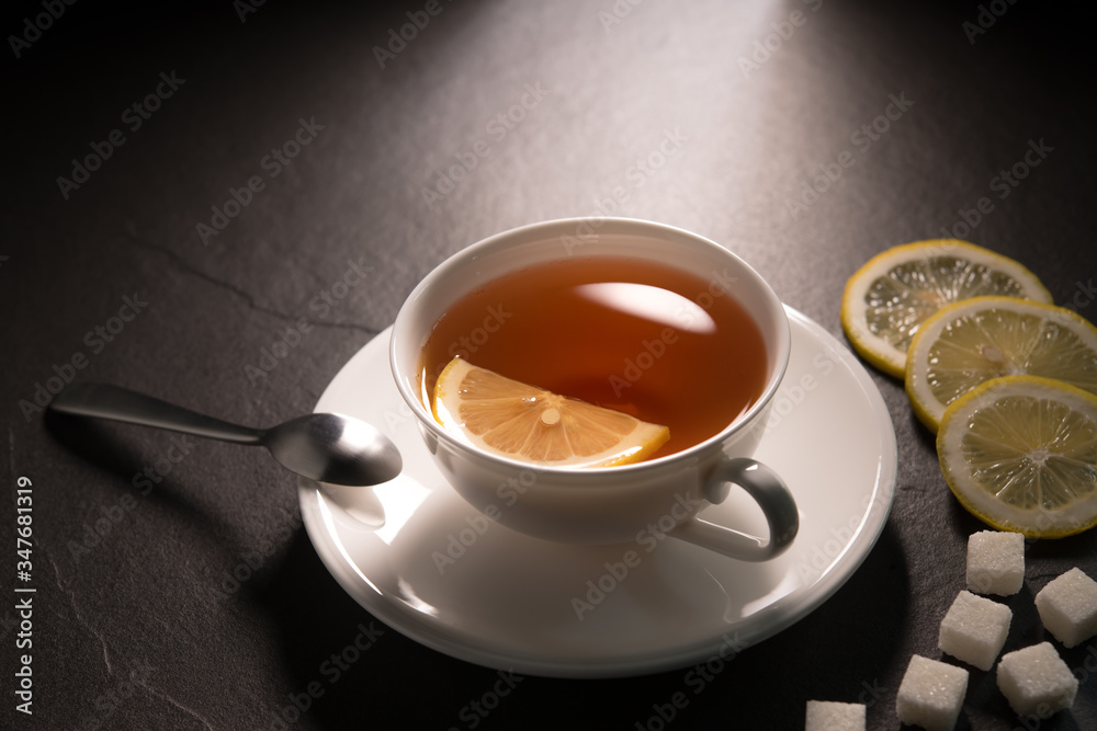  Cup of tea with lemon on black granite background