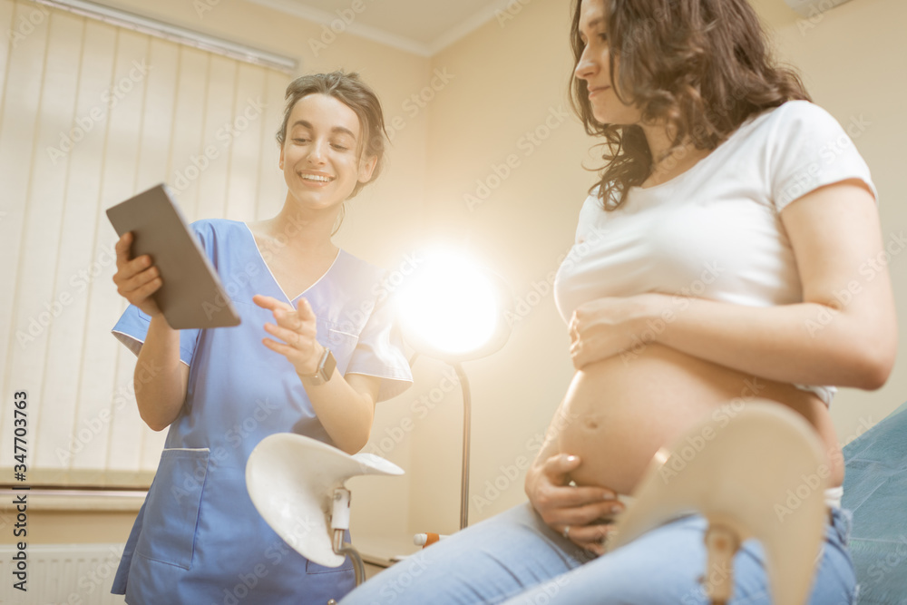 Nurse with pregnant woman during a medical consultation in gynecological office. Concept of medical 