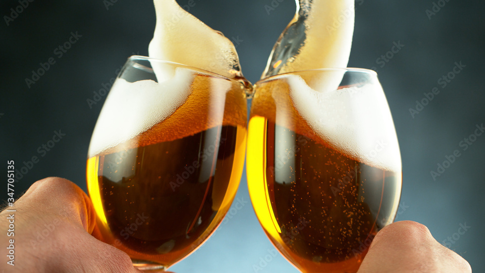 cheers, two glass beer mugs on grey background