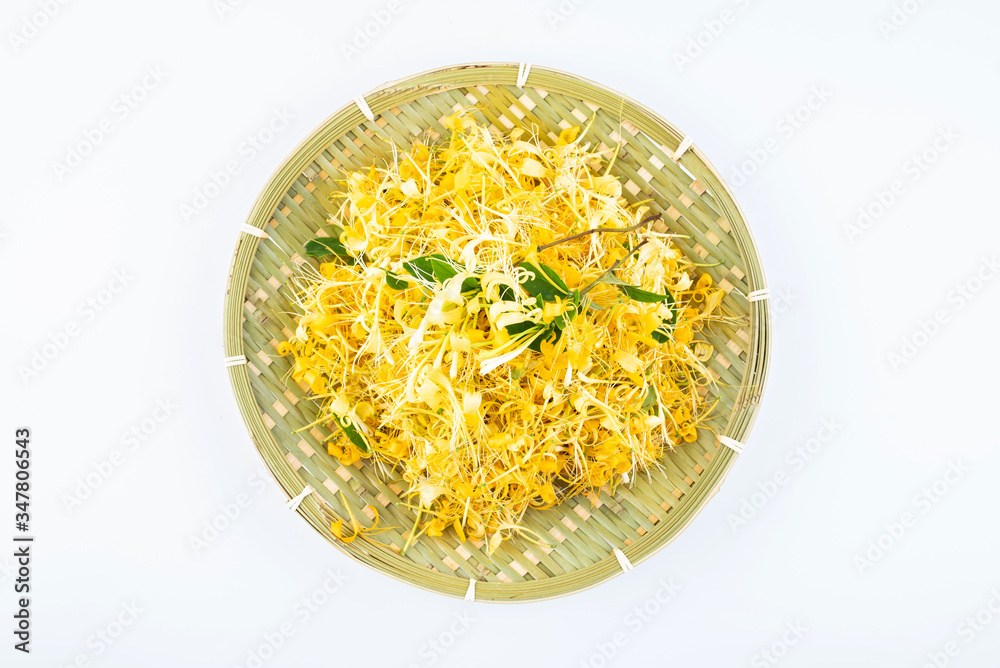 Golden wild honeysuckle in a bamboo sieve on white background