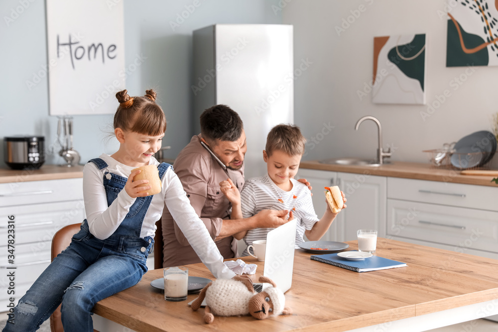 Little children keeping father from his work at home