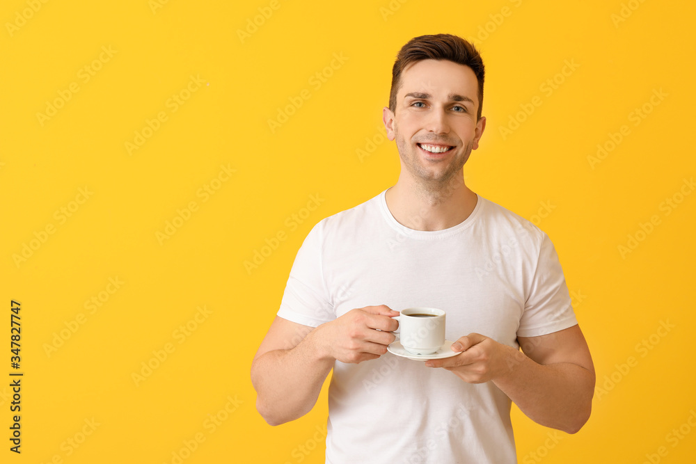 Handsome man with coffee on color background