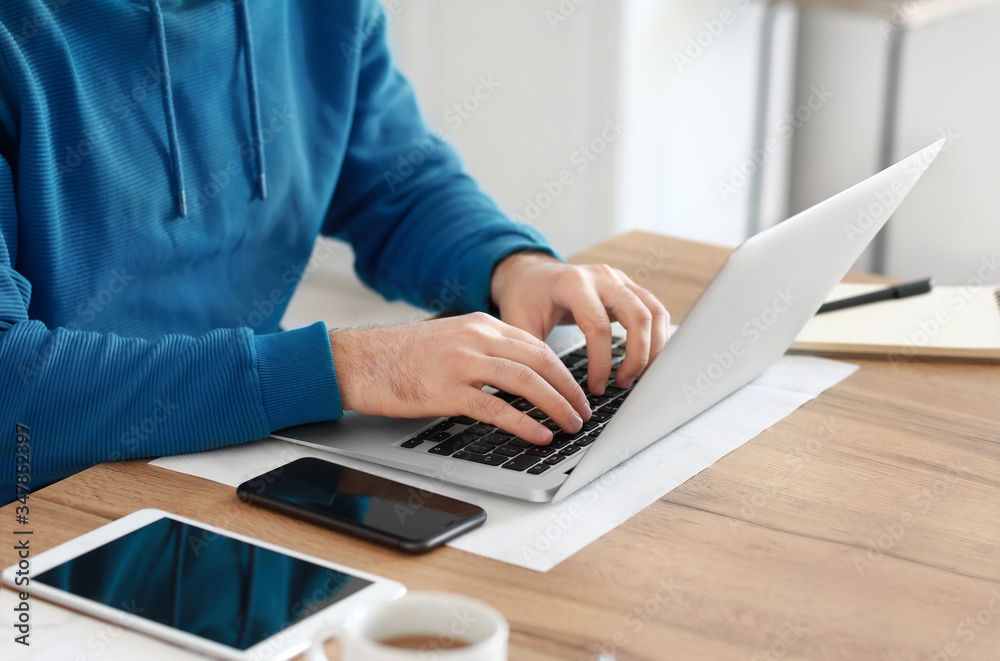 Young man with laptop working at home