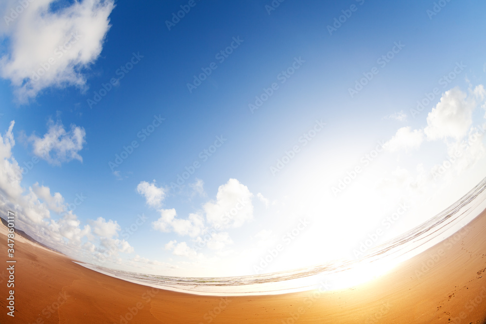 Wide angle view of sand, footprint and sunset clouds on the California beach