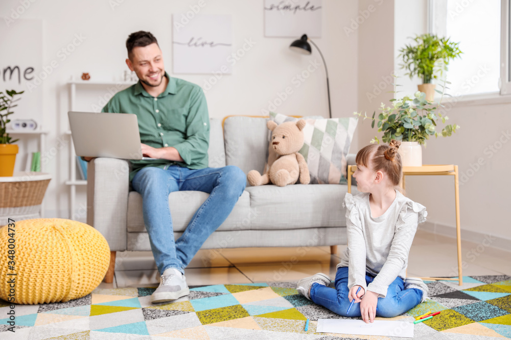 Working father with little daughter at home