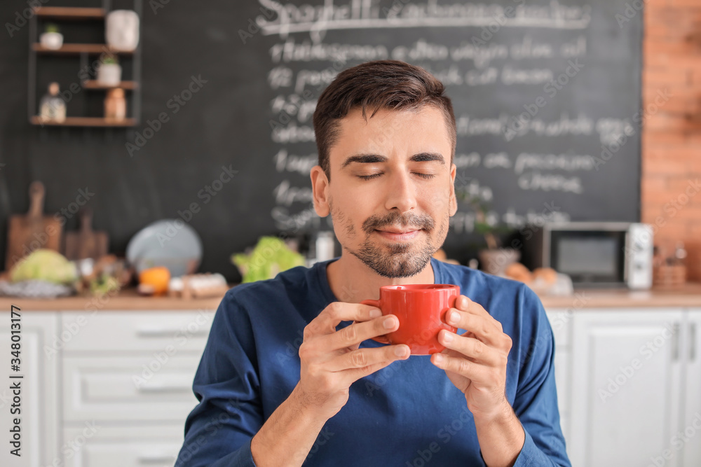 年轻人在厨房里喝着一杯热咖啡