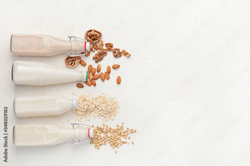 Bottles of different milk on white background