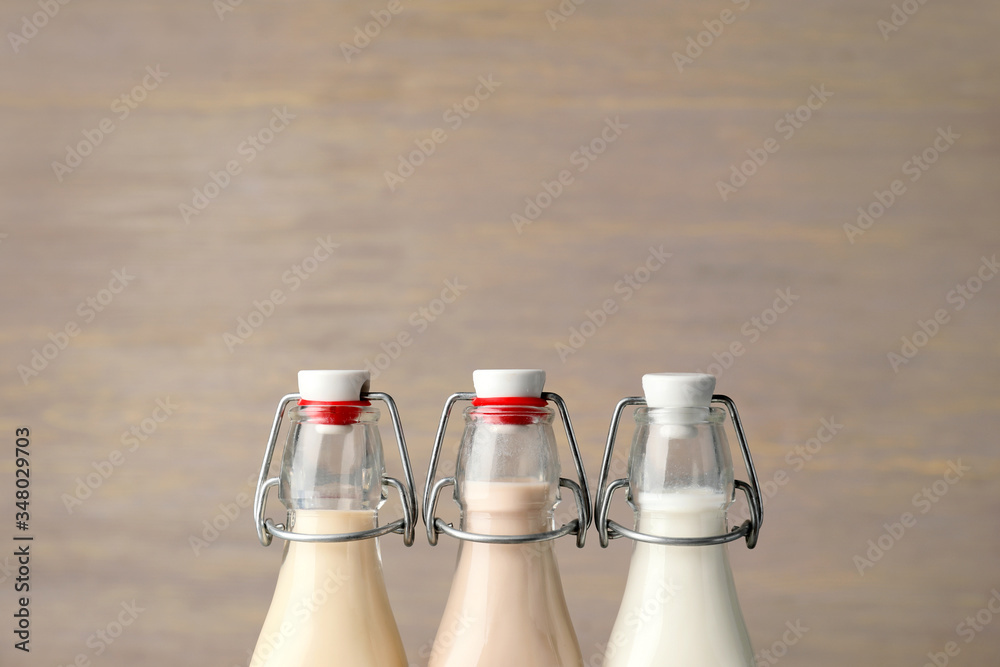 Bottles of different milk on wooden background