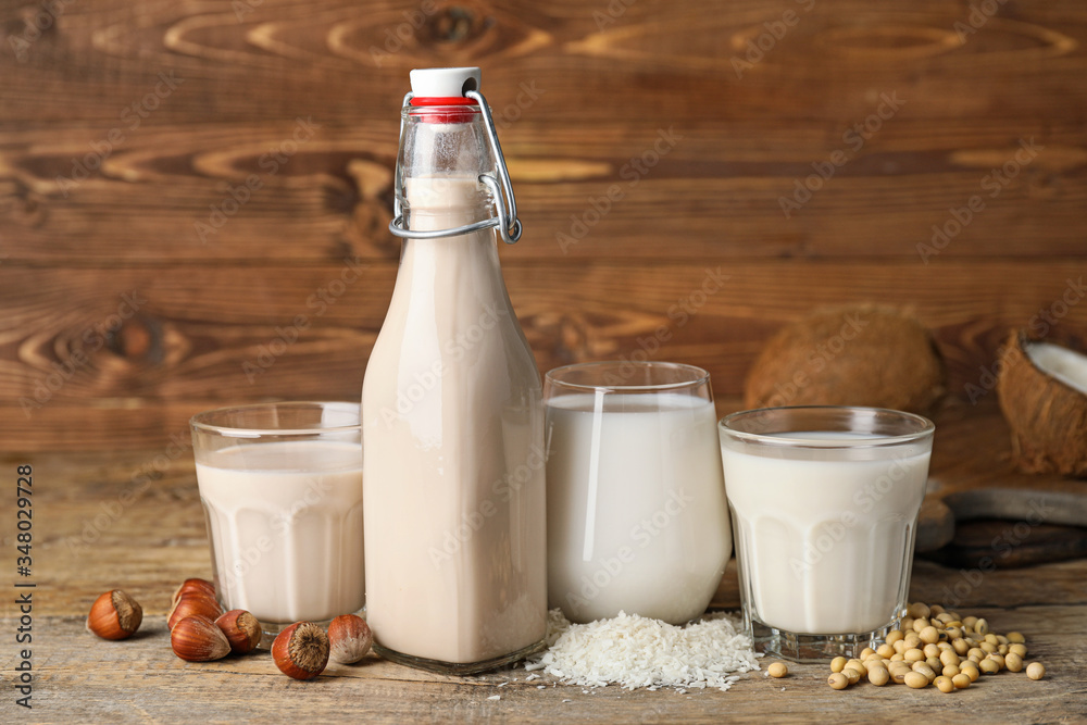 Different milk on wooden background