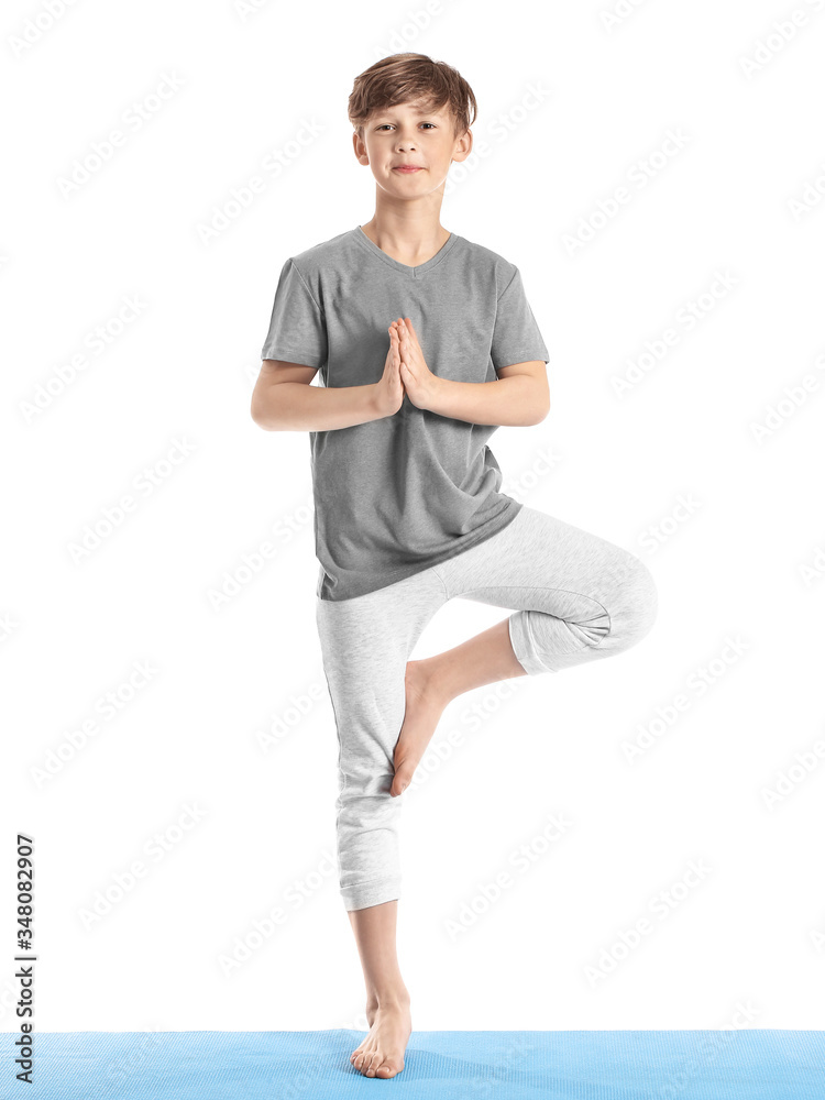 Cute little boy practicing yoga on white background