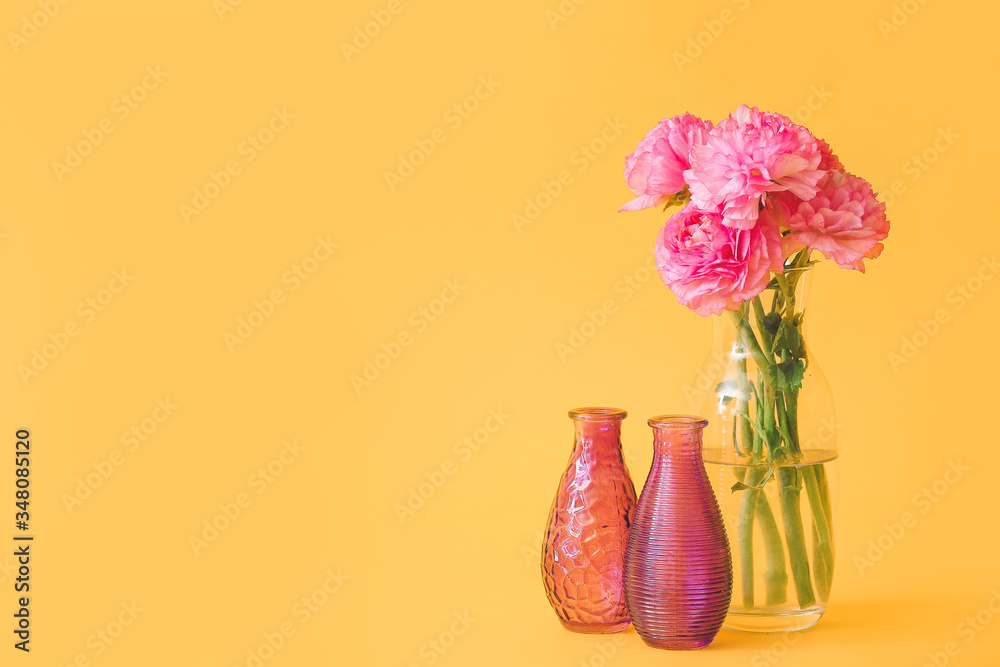 Different vases with bouquet of flowers on color background