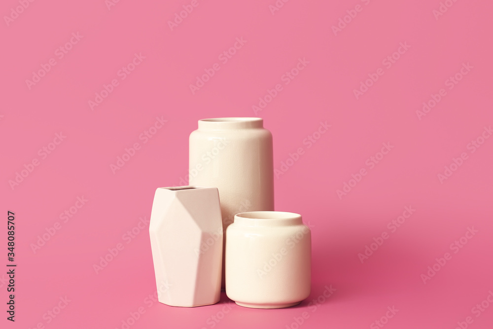 Different vases on color background