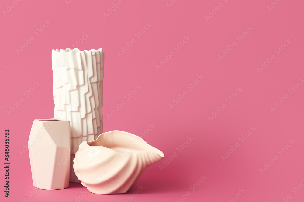 Different vases on color background