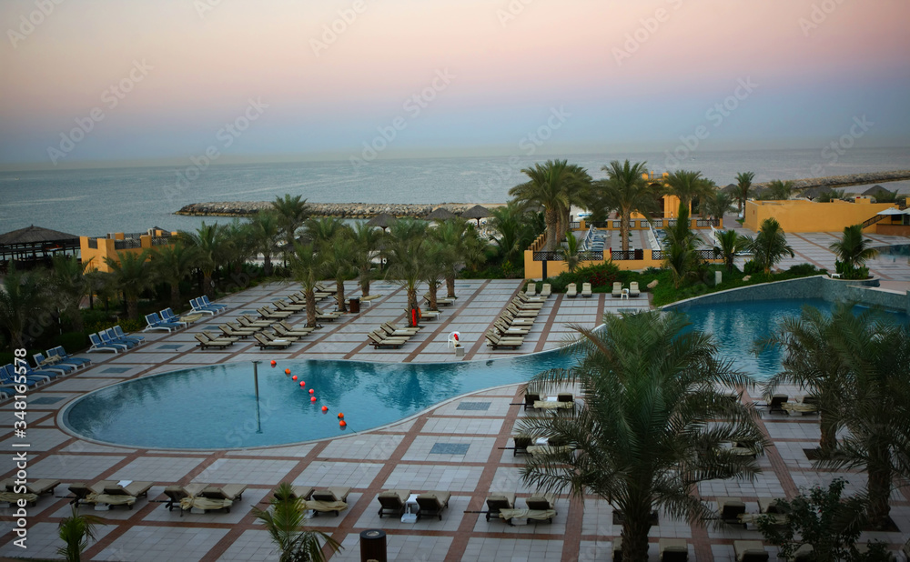 Poolat hotel. View from above at resort. Palms and water. Sunset at empty hotel. No people.