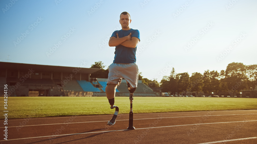 Athletic Disabled Fit Man with Prosthetic Running Blades is Posing with Crossed Arms on an Outdoor S