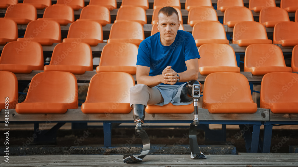 Athletic Disabled Fit Man with Prosthetic Running Blades is Preparing for a Training on an Outdoor S