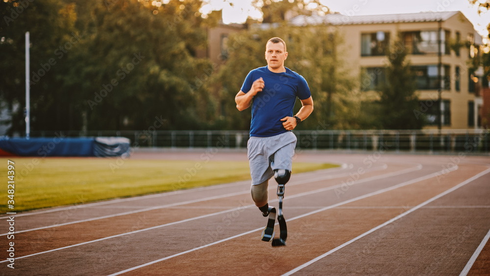 Athletic Disabled Fit Man with Prosthetic Running Blades is Training on a Outdoors Stadium on a Sunn