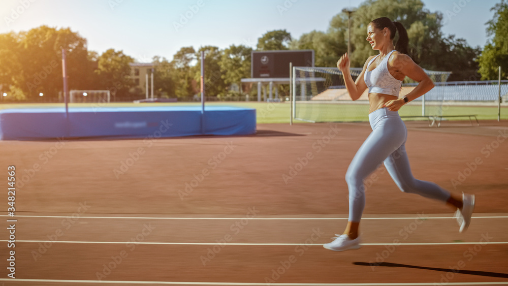 Beautiful Fitness Woman in Light Blue Athletic Top and Leggings Jogging in the Stadium. She is Runni