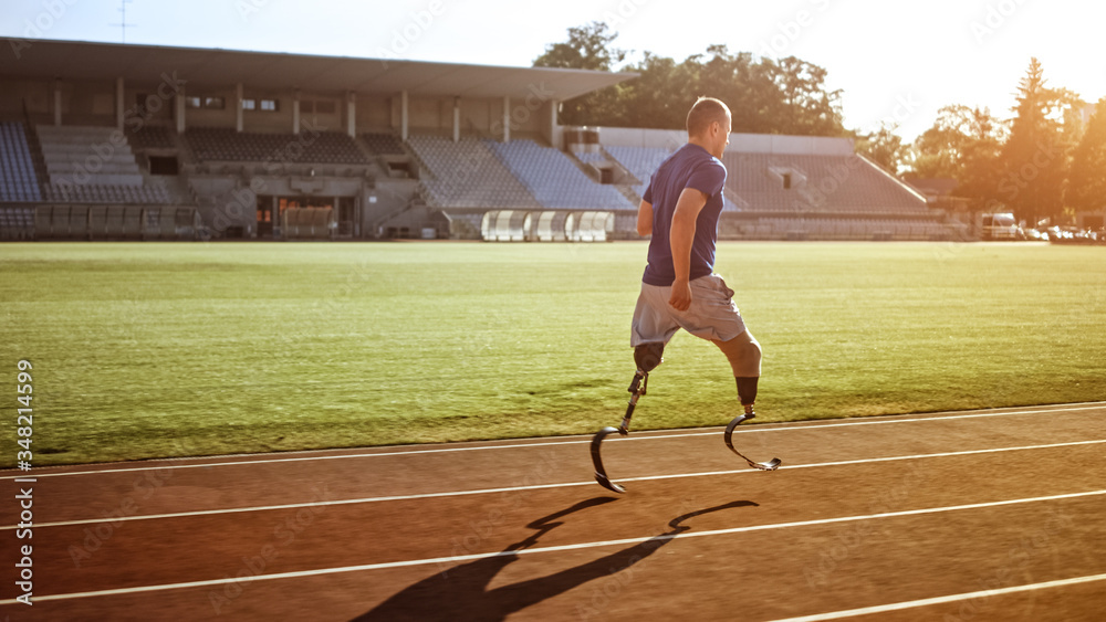 Athletic Disabled Fit Man with Prosthetic Running Blades is Training on an Outdoors Stadium on a Sun