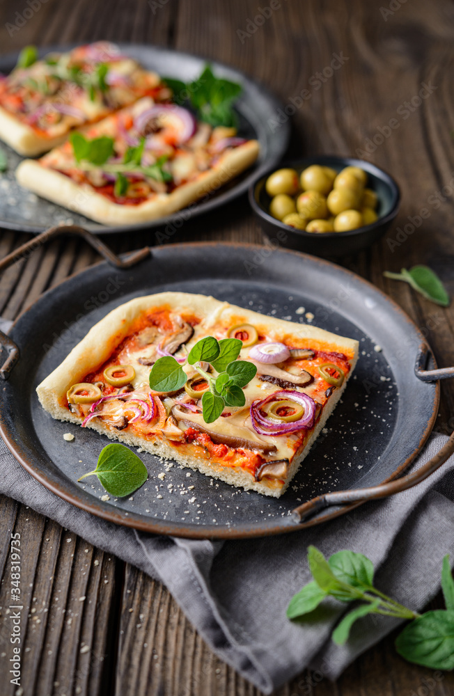 Homemade healthy Shiitake mushroom pizza topped with slices with green olives, cheese, red onion and