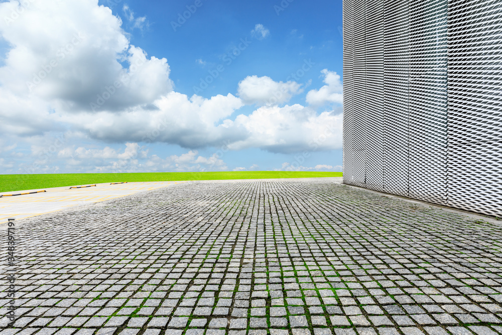 Empty square stone floor and wall with sky clouds.