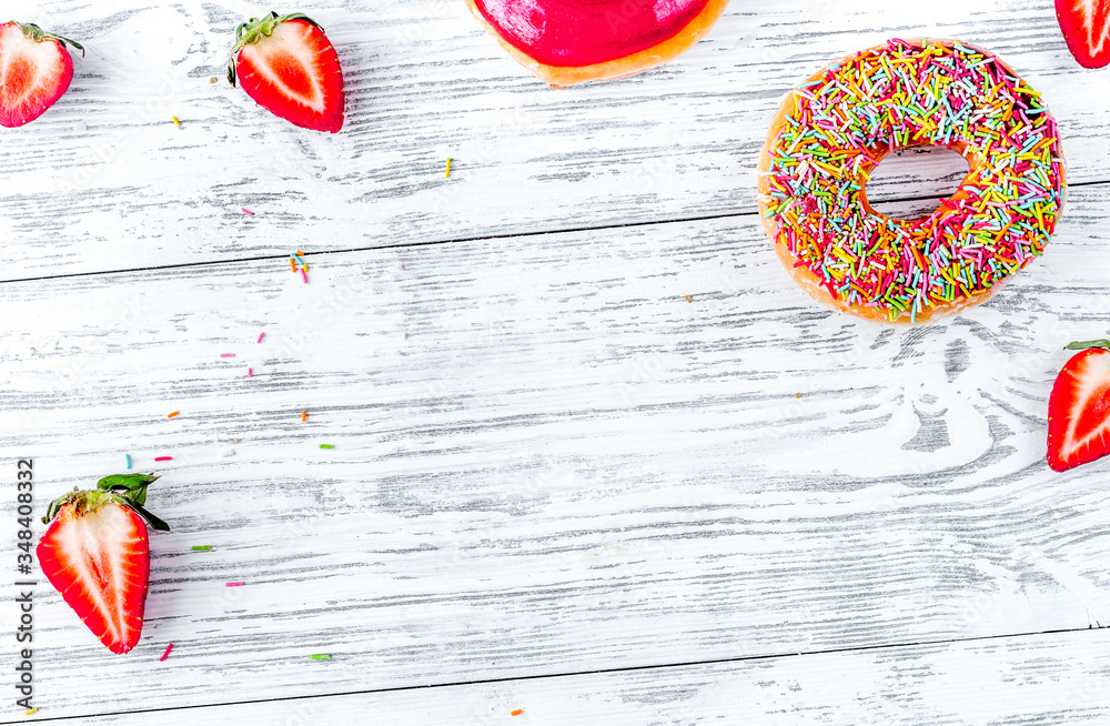 sweet colorful donuts with topping on wooden desk background top view mock-up