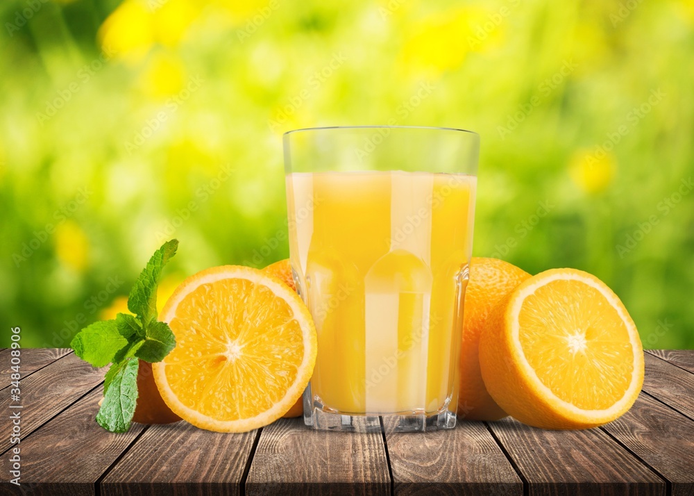 Orange juice and slices of orange on wooden desk