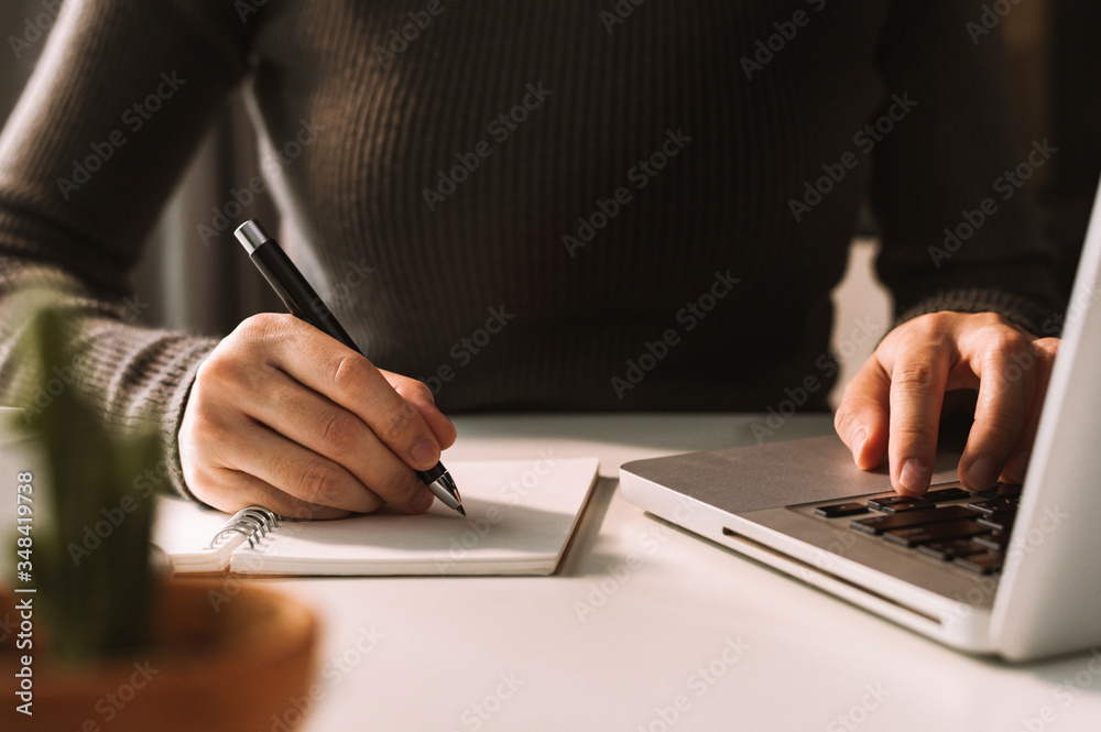 businessman hand working with new modern computer and writing on the notepad strategy diagram as con