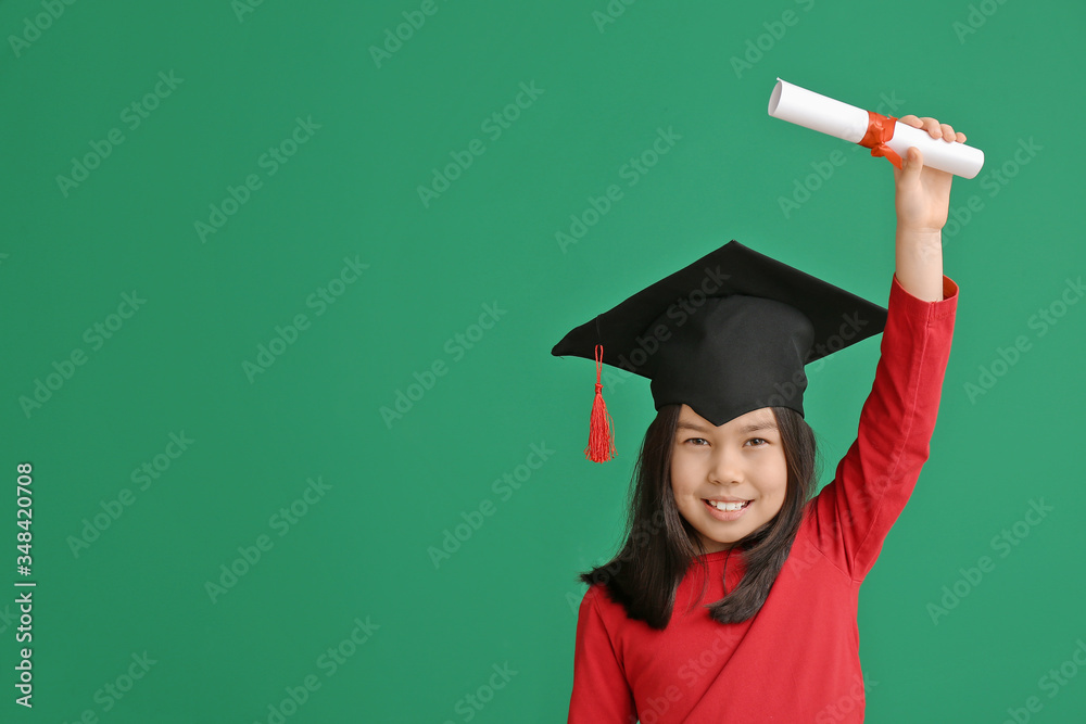 Little girl in graduation hat and with diploma on color background