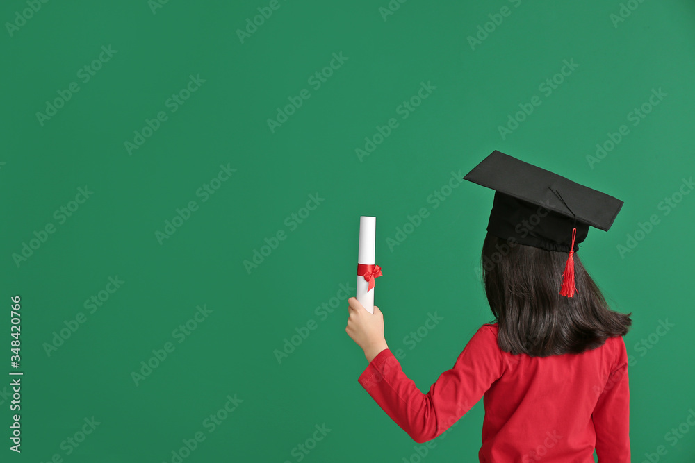 Little girl in graduation hat and with diploma on color background