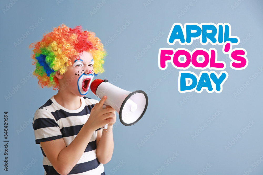 Cute little boy with clown makeup and megaphone on color background. April fools day celebration