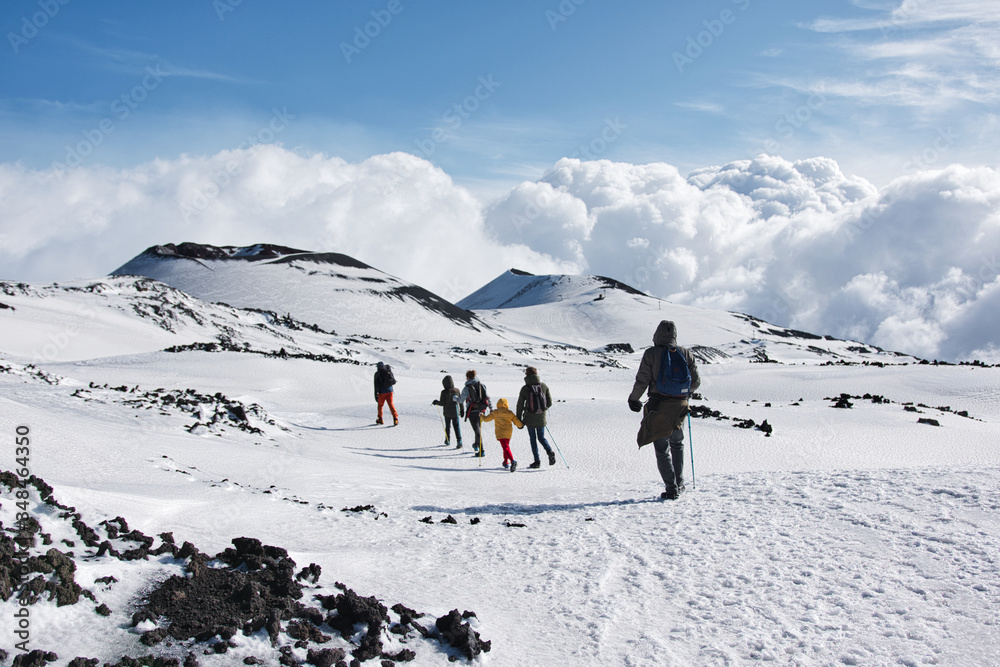 一家人在雪山上行走