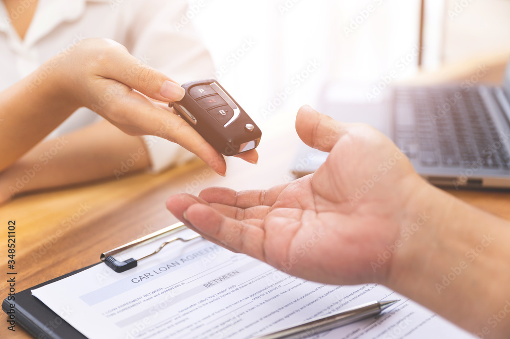 Car loan, contract agreement,buying and rent car concept, Saleperson holding car key on hand