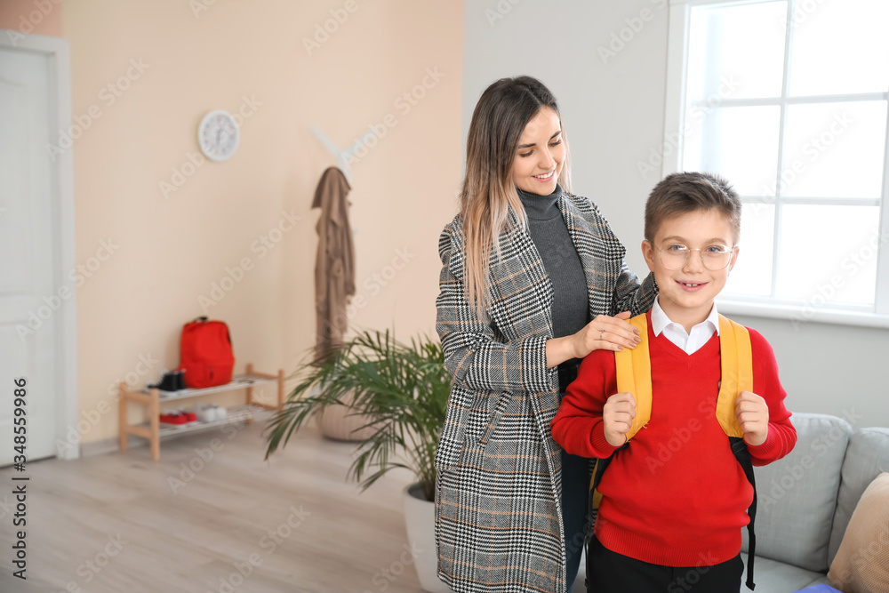 Cute schoolboy and his mother at home