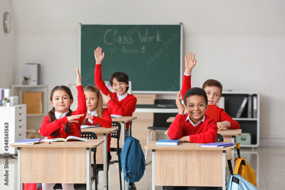 Cute little pupils during lesson at school