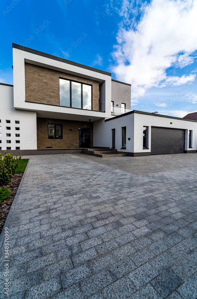 Cozy and modern house with garage and cobblestone driveway. Modern arhitecture.