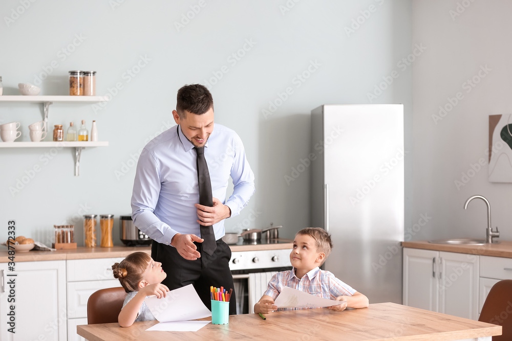 Happy children with father in kitchen at home