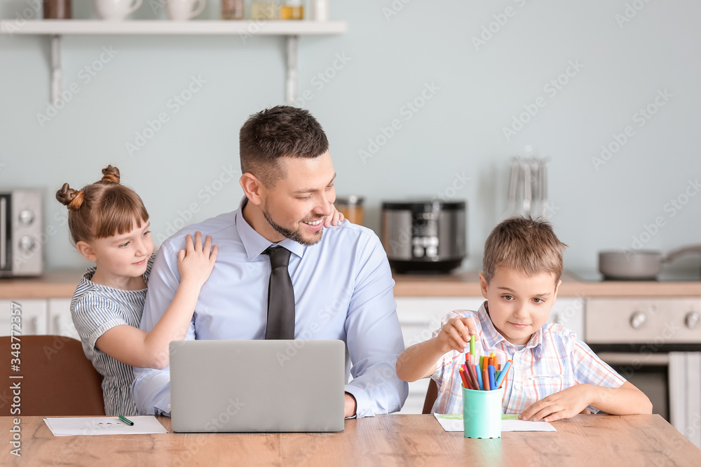 Working father with little children at home