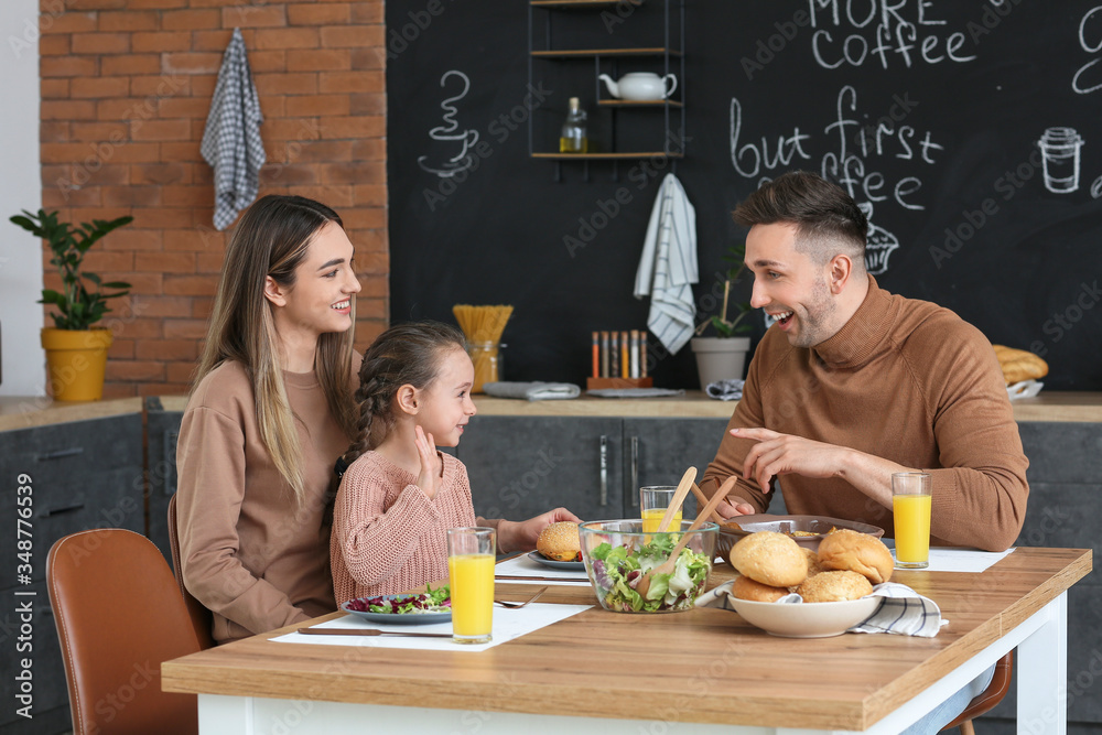 Happy family having dinner together in kitchen