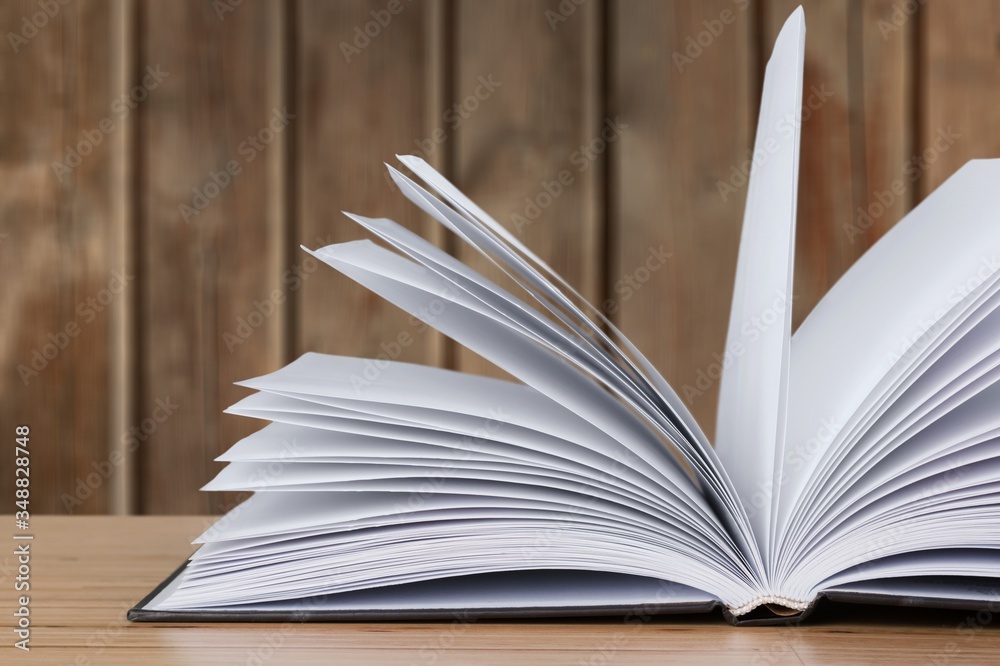 Open book on old wooden table.