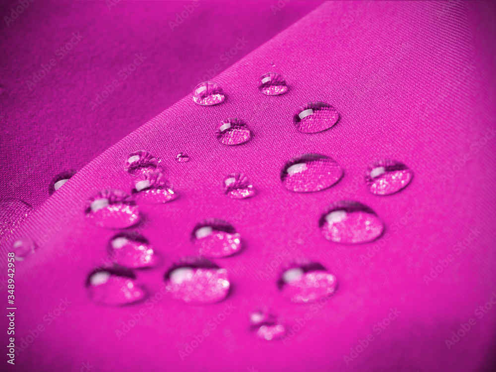 Magenta waterproof fabric with raindrops close up