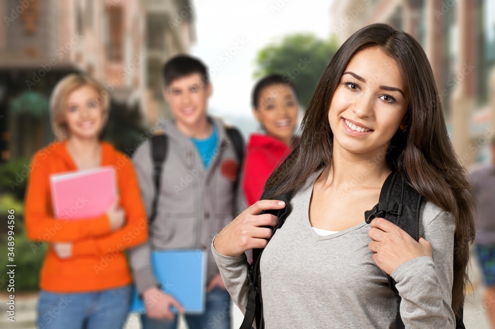 Young smile student girl with friends on the background