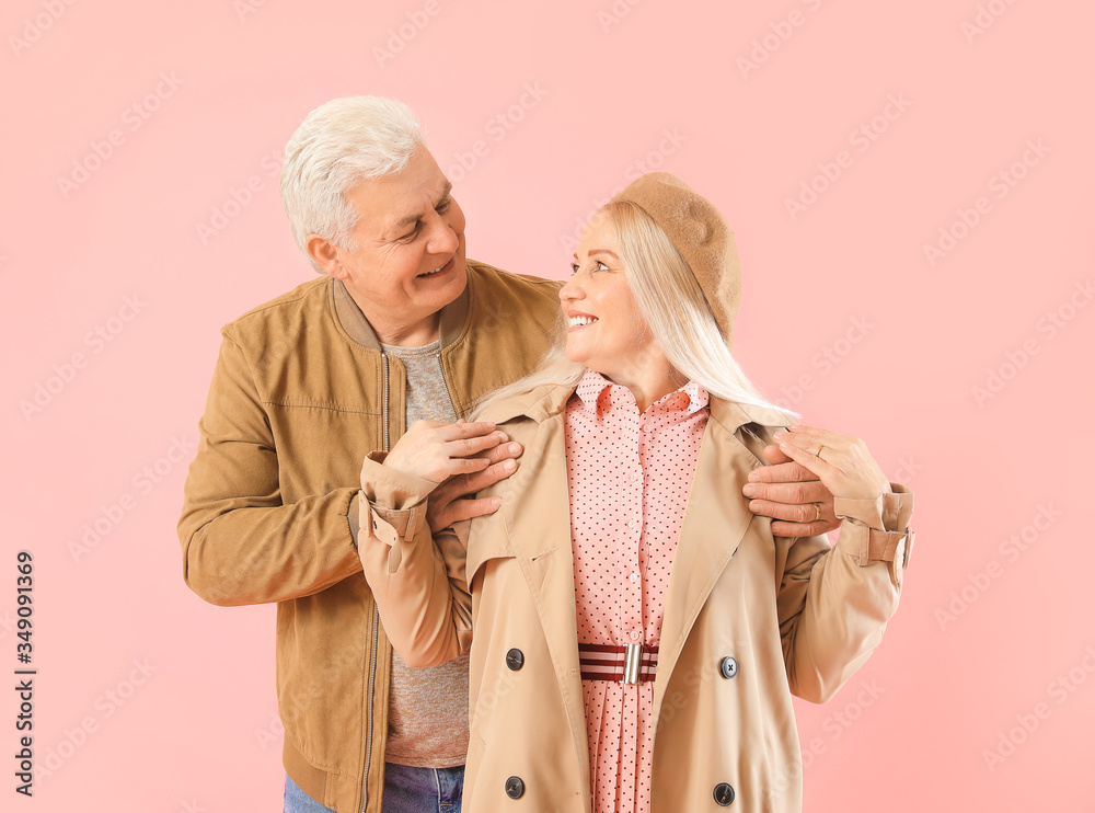 Portrait of happy elderly couple on color background