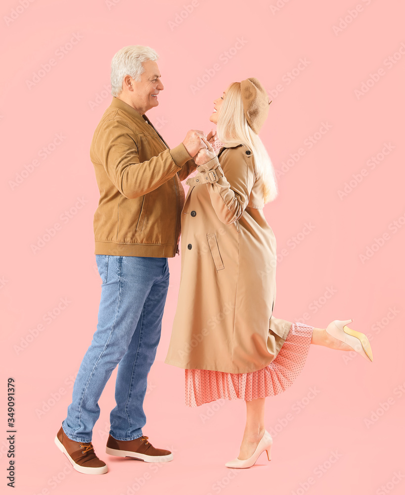 Portrait of happy elderly couple on color background